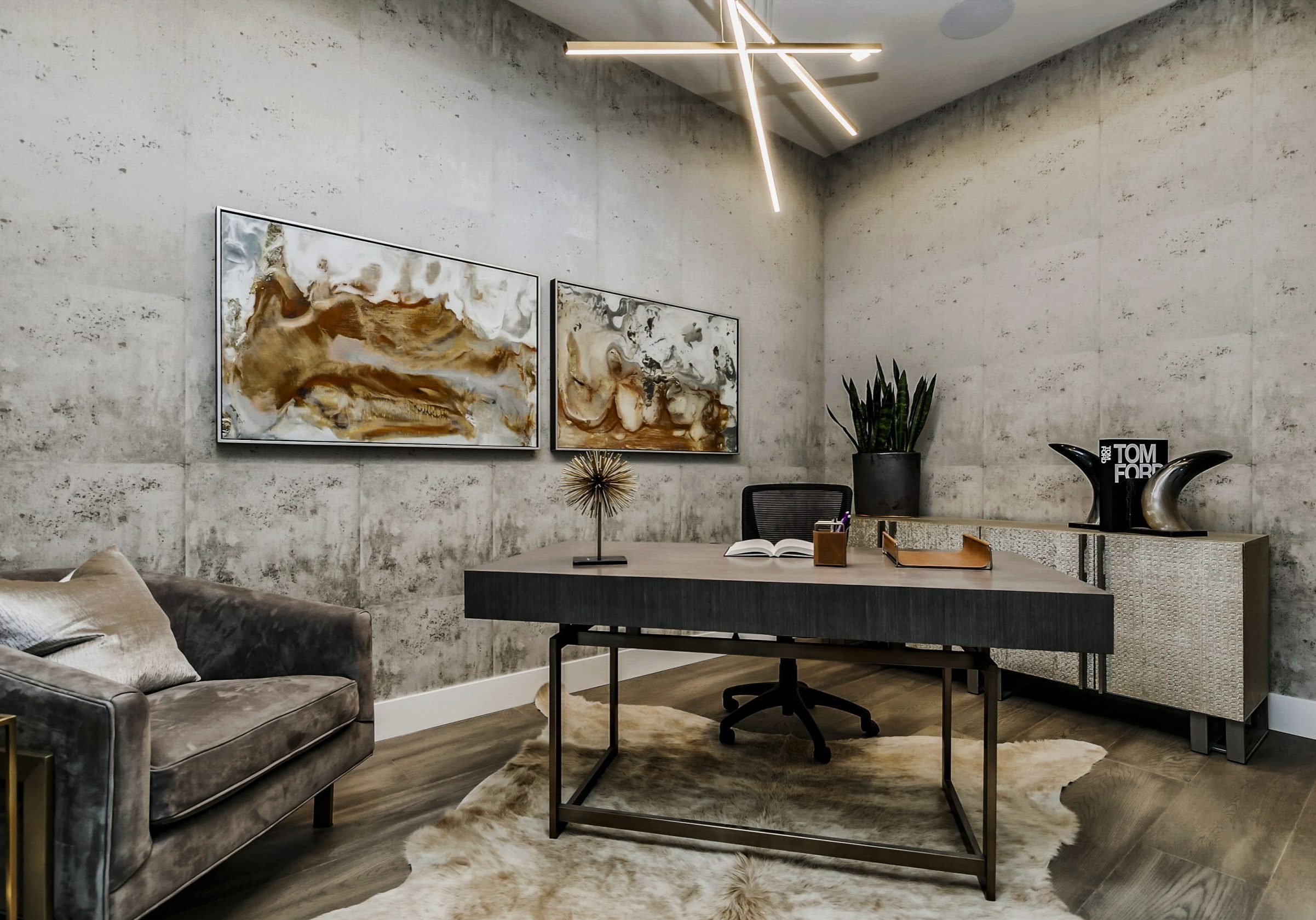 Modern office space with industrial wallpaper, rich warm gray furniture and a contemporary chandelier