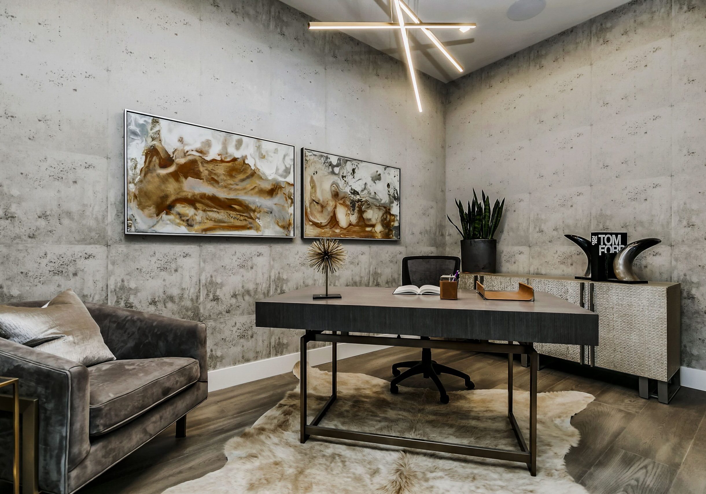 Modern office space with industrial wallpaper, rich warm gray furniture and a contemporary chandelier