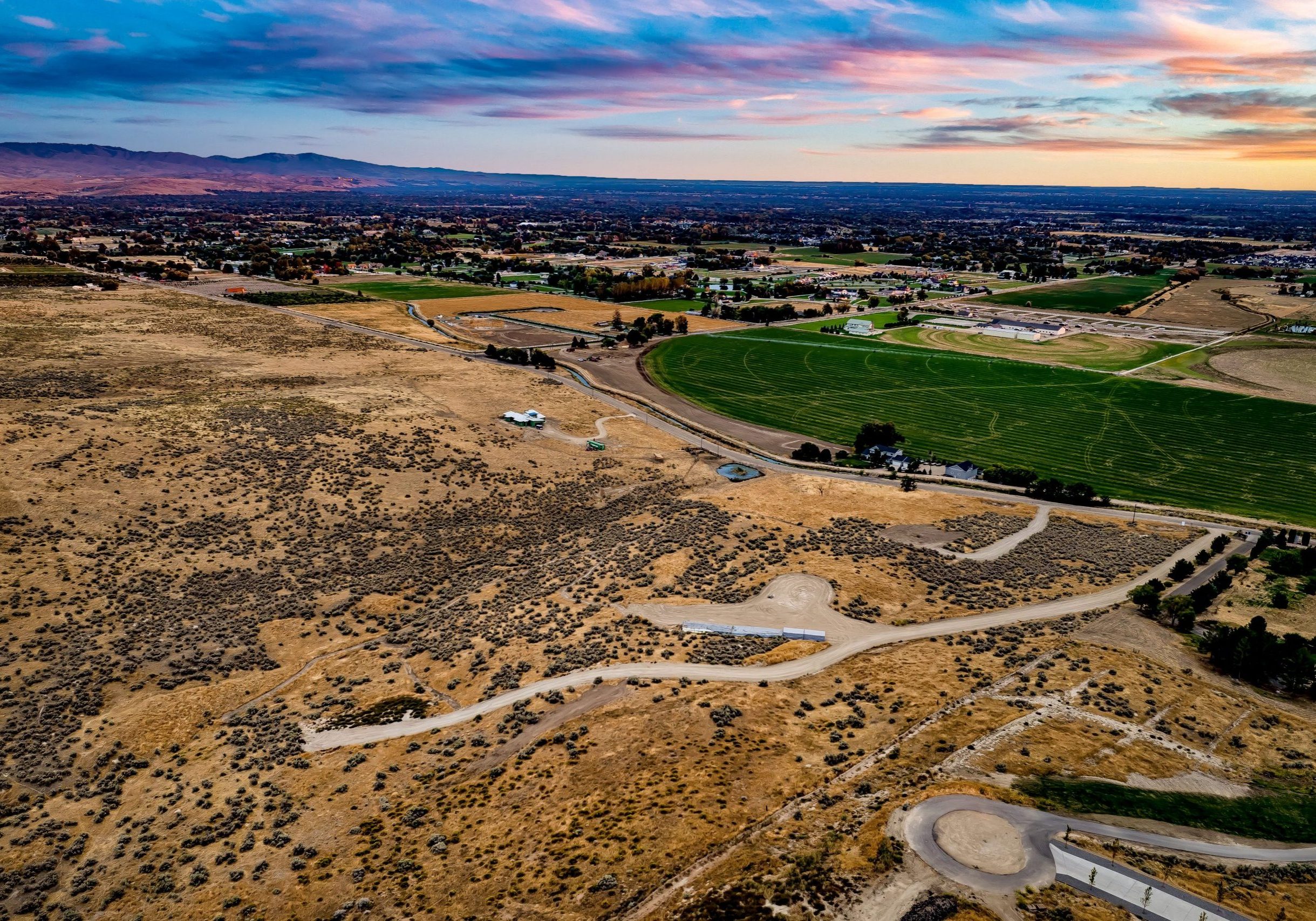 Aerial view of 17-acre Elkhorn Reserve community in the Eagle foothills at dusk. Boise and Eagle can be seen in the distance