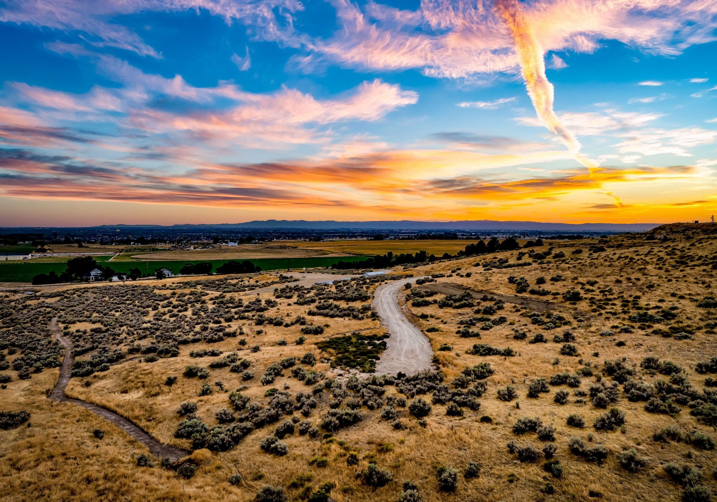 Aerial view of lot 1 in Eagle's Elkhorn Reserve community at dusk. Picturesque sunset sky with warm colors above the foothills.