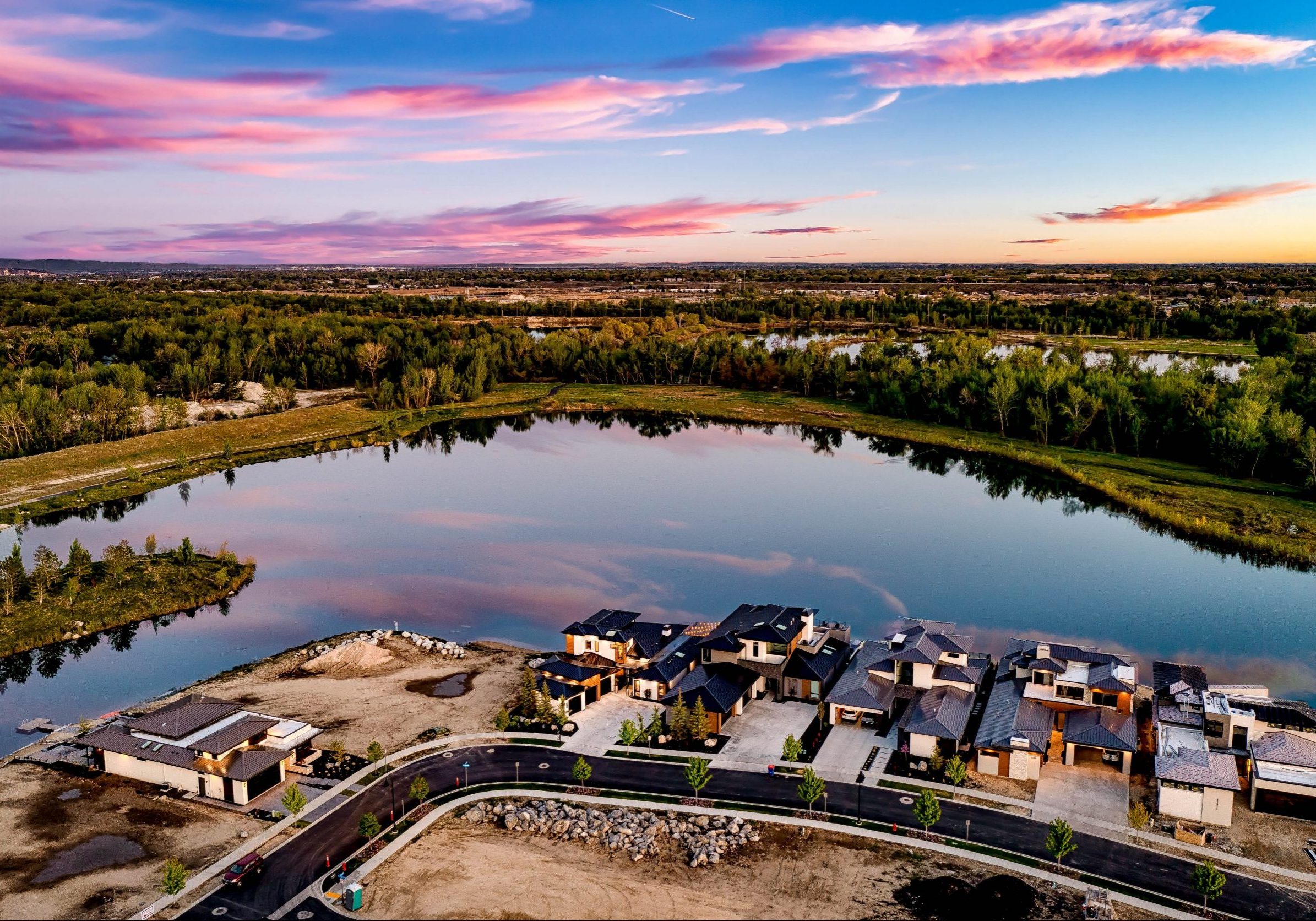 Aerial view of waterfront luxury homes in the Renovare community with adjacent available lots under construction